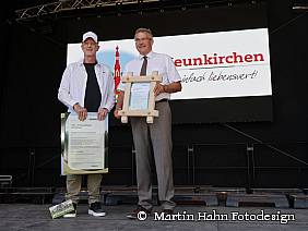 Karsten Thiel übergibt Bürgermeister Bernhard Knörzer ein Klimaschutzzertifikat